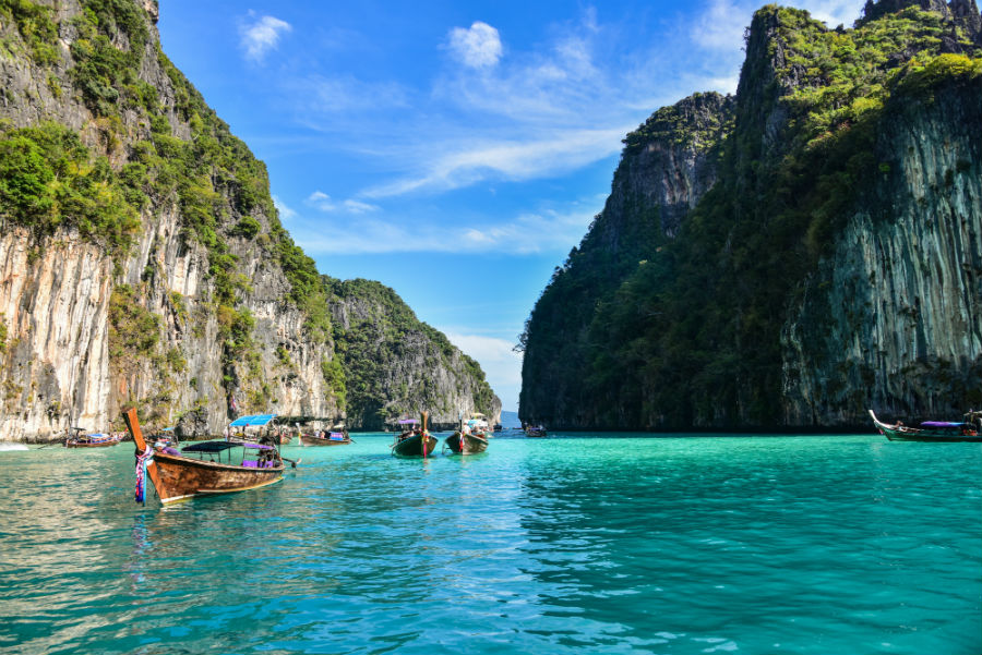 A rocky cove in thailand with boats