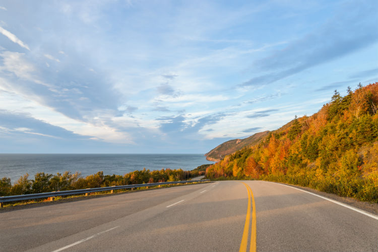 An open road along the Nova Scotia coast during the autumn and at sunset. 