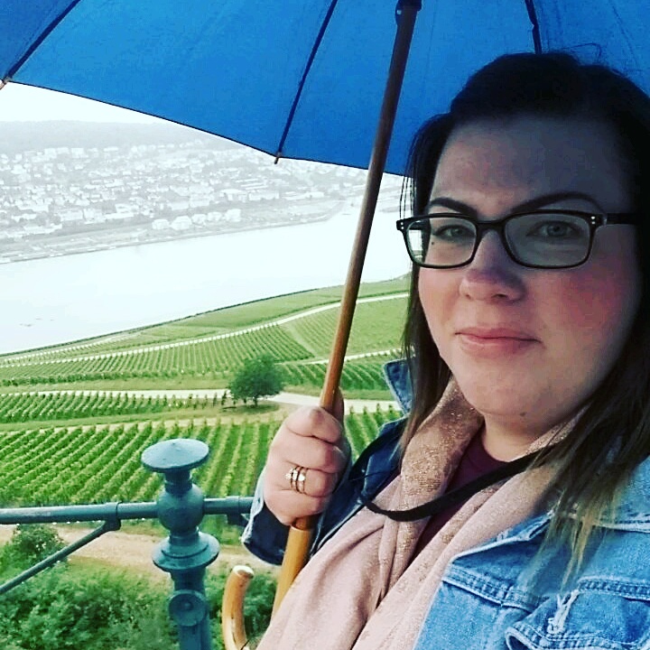 Melanie - a brown haired woman - with an umbrella overlooking Breisach! 