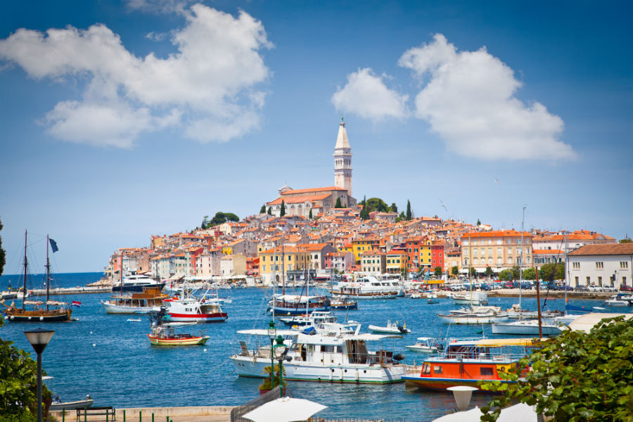 Old Istrian town in Rovinj Croatia during the day with lots of boats in the harbour. 