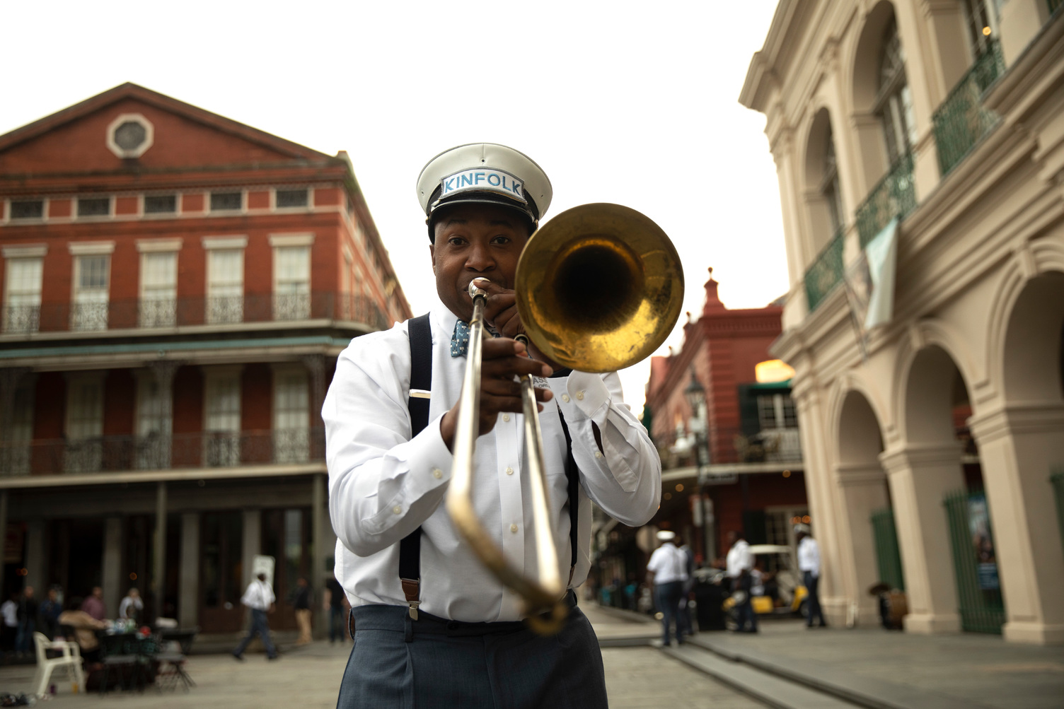 A man with a trumpet looking directly into the camera on a New Orleans street. 