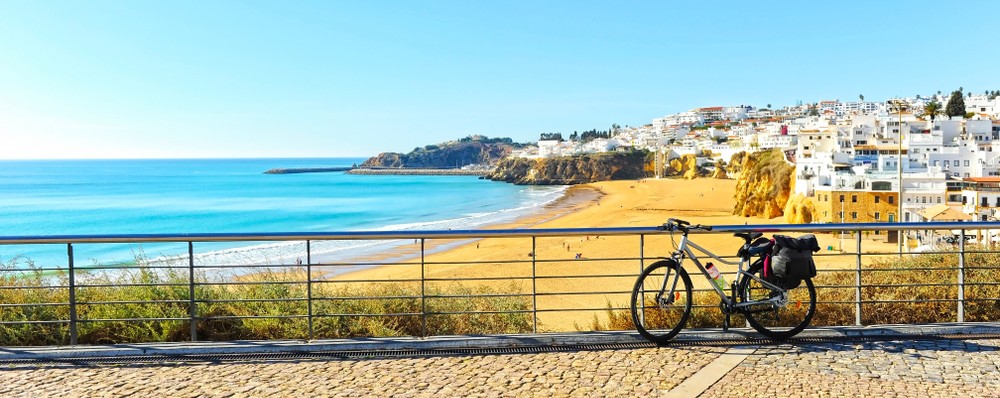 A sunny day on Algarve beach with a bike in the foreground.